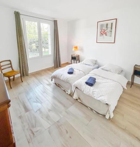 une chambre avec deux lits et une grande fenêtre dans l'établissement L'Ecrin de la Jolie, à Mantes-la-Jolie