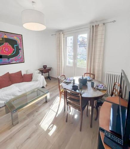 un salon avec une table et un canapé dans l'établissement L'Ecrin de la Jolie, à Mantes-la-Jolie