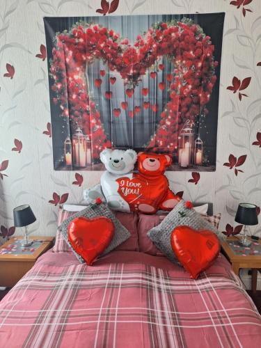 a bedroom with a bed with two stuffed animals and hearts at The Garnett in Blackpool