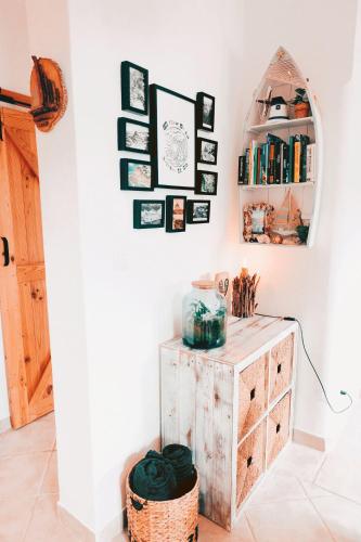 a room with a wooden cabinet and a shelf with books at Um Lugar ao Sol Beach House Azenhas do Mar in Sintra