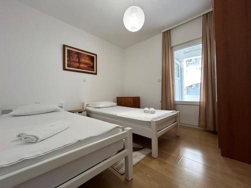 a white room with two beds and a window at Anchor Apartment in Stanići Near Omiš in Stanići
