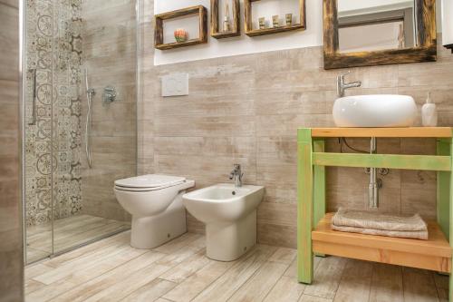 a bathroom with a toilet and a sink and a shower at B&B Les Chambres Rooms & Suite in Santa Teresa Gallura