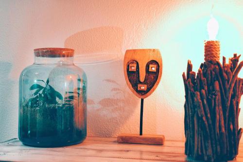 a glass jar sitting on a table next to a candle at Um Lugar ao Sol Beach House Azenhas do Mar in Sintra