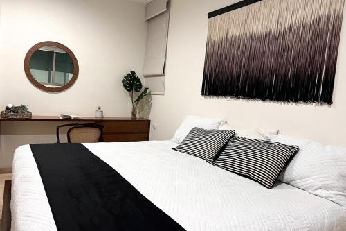a bedroom with a bed with two black and white pillows at Condo Playa & Waterfront Heated Alberca in Mazatlán