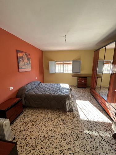 a bedroom with orange walls and a bed at Casa Rural Los Laureles in Venta del Baúl