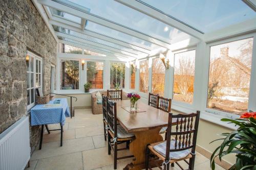 a conservatory dining room with a table and chairs at IVY COTTAGE in Pulborough