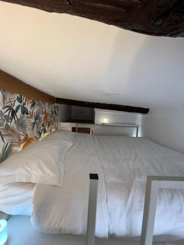 une chambre avec un lit blanc dans une pièce dans l'établissement Studio nel cuore della città, à Nice