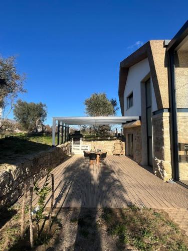 a wooden deck with a picnic table in front of a building at Quinta da Sra Marocas in Covilhã