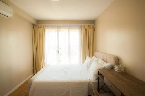 a bedroom with a white bed and a window at Casa - Coastal Getaway Two-Bedroom Vacation Home with free parking in Amalfi by City de Mare in Cebu City