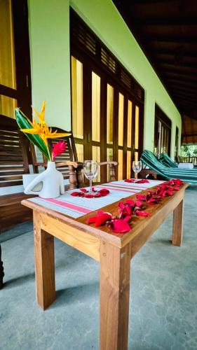 a wooden table with red roses on top of it at Villa Arana Bentota in Bentota