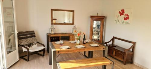 a dining room with a wooden table and chairs at Venez vous ressourcer au calme in Locmaria-Grand-Champ