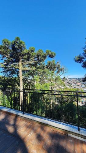 a fence on a deck with a tree in the background at Deslumbrante Flat no Serra Class in Canela