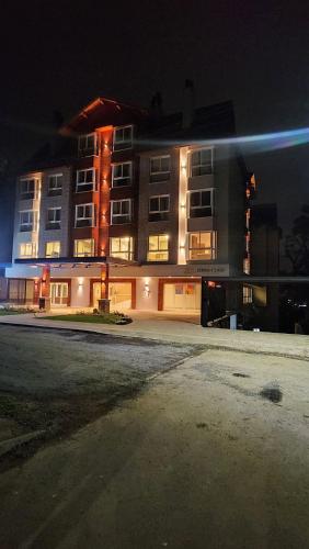 a building at night with a street in front of it at Deslumbrante Flat no Serra Class in Canela