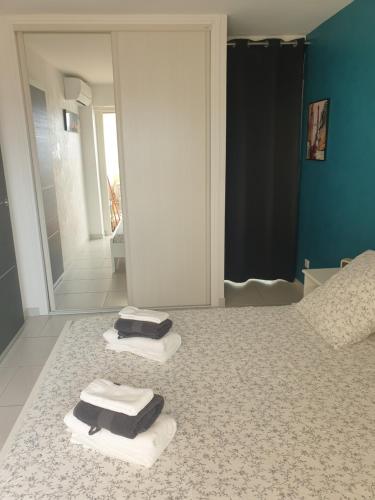 - une salle de bains avec 2 serviettes sur un lit et un miroir dans l'établissement Il Leone di Cecilia, à Antibes