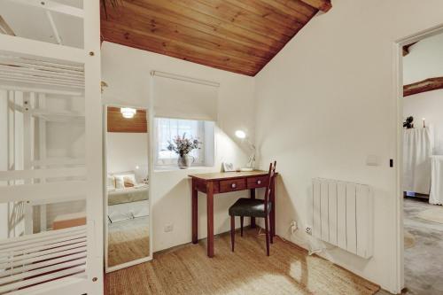 a room with a desk and a mirror and a bedroom at Refúgio da Alma in Mafra
