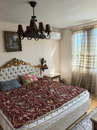 a bedroom with a large bed and a chandelier at Вила Езерото in Lipnik