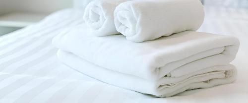 a stack of white towels sitting on top of a bed at Csiki Hotel in Miercurea-Ciuc