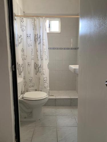 a bathroom with a toilet and a shower curtain at Refugio para descansar in La Paz