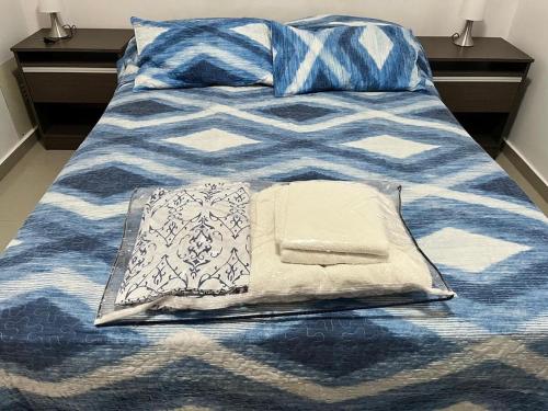 a blue and white bed with two pillows on it at Alojamiento Puerto Madryn a metros del Mar in Puerto Madryn