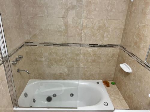 a bathroom with a bath tub with a shower at Alojamiento Puerto Madryn a metros del Mar in Puerto Madryn