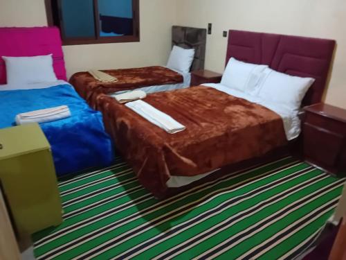 a hotel room with two beds in a room at Maison D'hôtes Chez Bassou Agoudal in Agoudal