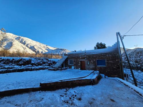 a brick building with stairs in the snow at Tayda Guest House in Azilal