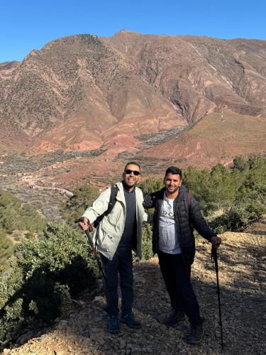 two men standing on top of a mountain at Tayda Guest House in Azilal