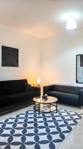 a living room with black couches and a coffee table at Spacious 2 Bed Apart with Patio in Camden WR201 in London