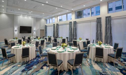デルレイビーチにあるHyatt Place Delray Beachのテーブルと椅子とスクリーンを備えた会議室