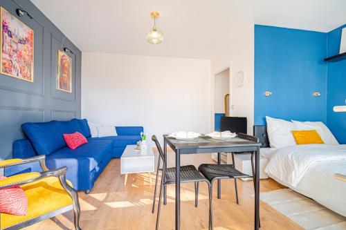 a room with a bed and a table and a couch at L 'Écrin d' Ermont in Ermont
