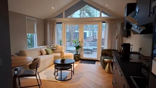 a living room with a couch and a table at Snoozz retreats in Haarle
