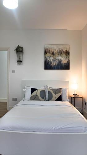 a bedroom with a large white bed with two pillows at Duplex 3 Bed Apt with patio in Camden WR202 in London