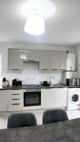 a kitchen with white appliances and a table and chairs at Duplex 3 Bed Apt with patio in Camden WR202 in London