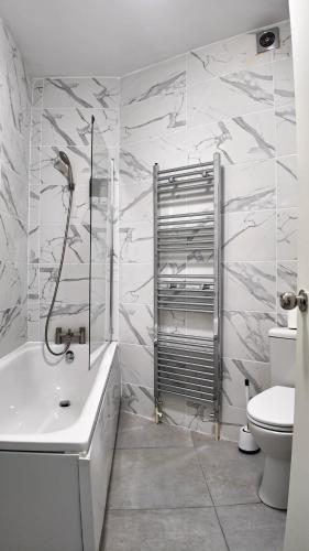 a bathroom with a shower and a tub and a toilet at Duplex 3 Bed Apt with patio in Camden WR202 in London