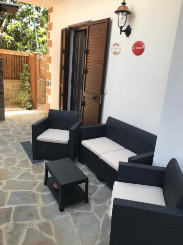 a patio with couches and a table and a door at BOUGAINVILLEA Relax e Mare a 50m, in Centro! in Marina di Casalvelino
