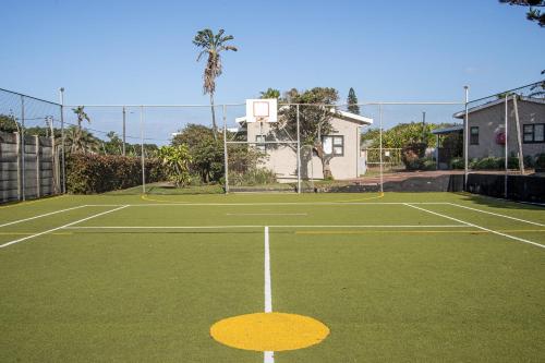 a tennis court with a basketball hoop at Tranquility - Banana Beach Club in Port Shepstone