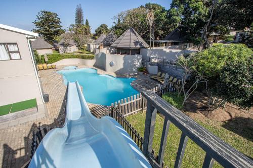 a blue water slide in a backyard at Tranquility - Banana Beach Club in Port Shepstone