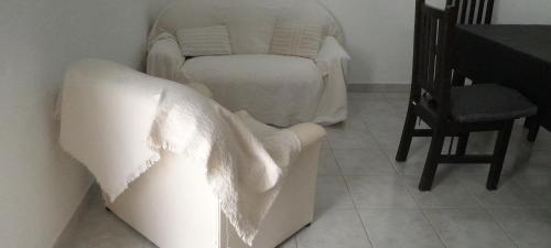 - un salon avec un canapé blanc et une chaise dans l'établissement Kalma, à Villa Elisa