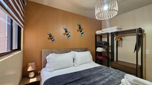 a bedroom with a bed with blue birds on the wall at PERFEITO 1dorm, piscina, Intermares com garagem in Nossa Senhora do Livramento