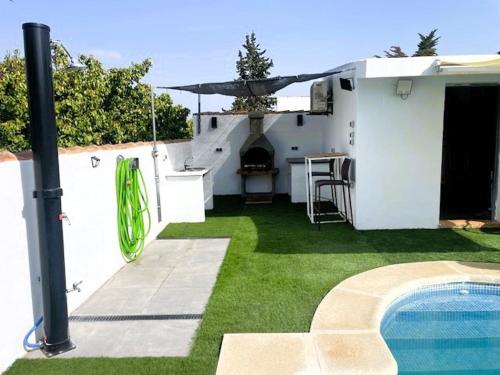 a backyard with a swimming pool next to a house at Chalet Familiar Relax con piscina in Chiclana de la Frontera