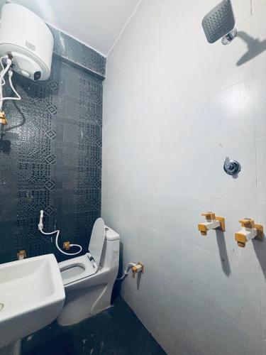 a bathroom with a white toilet and a sink at Radha Madhavam Luxurious Boutique Stay in Mathura