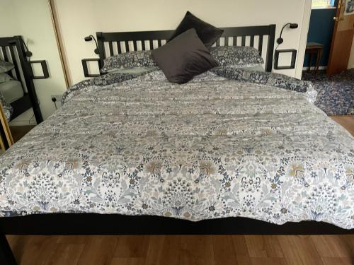 a bed with a blue and white comforter on it at Old Egg Shop in Holywood