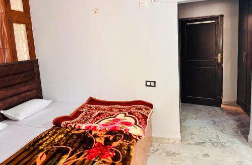 a bed with a colorful blanket on top of it at Radha Madhavam Luxurious Boutique Stay in Mathura