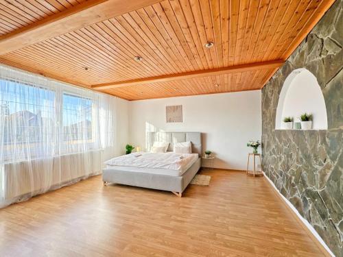 a bedroom with a bed and a stone wall at Vila Baška in Frýdek-Místek