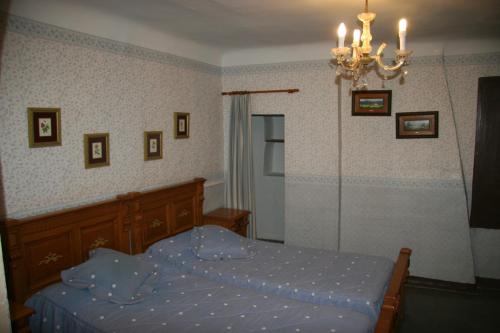 a bedroom with a bed and a chandelier at casa rural Mas Pare Sant in Alcoy