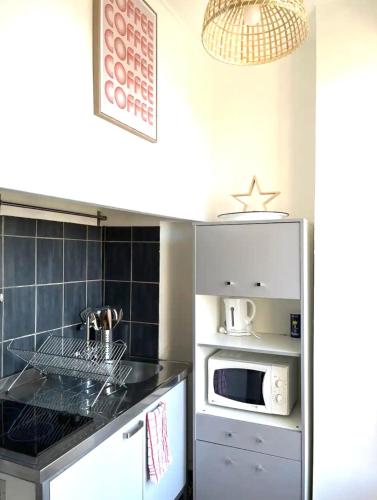 une cuisine avec un réfrigérateur et un micro-ondes dans l'établissement Studio avec vue mer en plein cœur du Panier, à Marseille