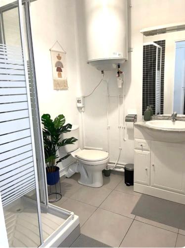 une salle de bain blanche avec des toilettes et un lavabo dans l'établissement Studio avec vue mer en plein cœur du Panier, à Marseille