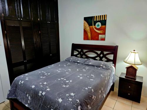 a bedroom with a bed and a lamp on a night stand at 3 bedroom townhouse in Diego Martin