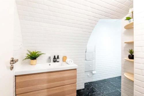 une salle de bain blanche avec un lavabo et un miroir dans l'établissement Keyz - Spacious 2BD in the heart of Le Marais, à Paris