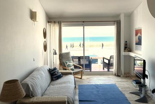 a living room with a couch and a view of the beach at Casa do Mar -Sea house in Nazaré